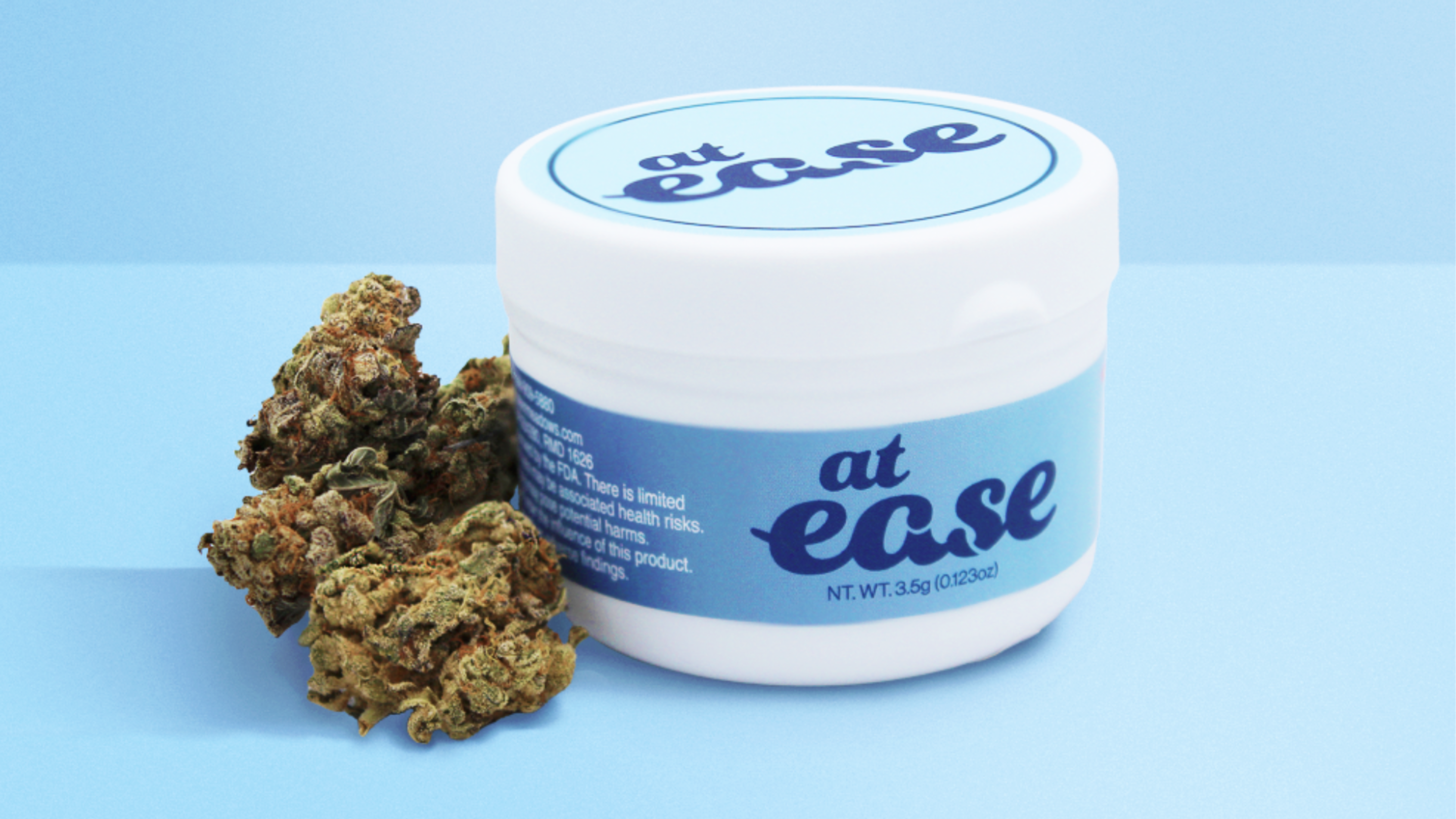 at ease product photography on baby blue background with cannabis flower in shot